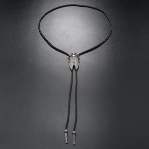 Detail of vintage silver cicada metal slide on black braided bolo tie leather cord necklace