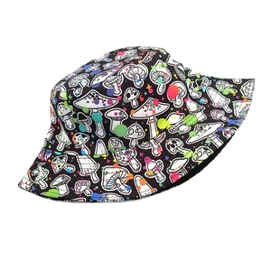Detail view of reversible bucket hat featuring white mushroom prints and colorful ink splashes