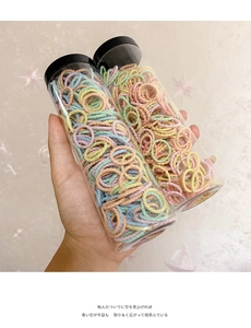 Detail von zwei Gläsern mit bunten elastischen Haarbändern für Mädchen und Kinder