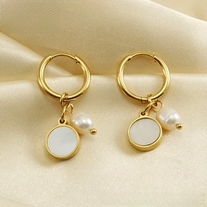 Detalle de pendientes bañados en oro 18K con colgantes de nácar y perlas barrocas