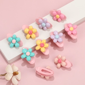 Sweet floral hair clips set for girls in various pastel colors on a pink background