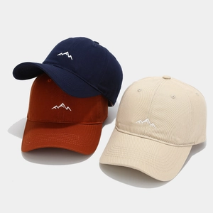 Three minimalist mountain embroidery baseball caps in navy blue, brick red, and beige colors