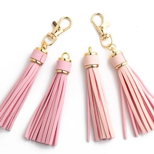 Detail view of pink PU leather tassels with golden hooks in dark and light shades