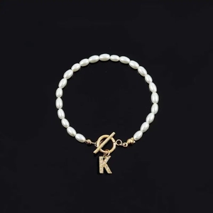 Fashion pearl bracelet featuring white oval beads, gold T-bar clasp and letter K charm