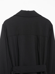 Detail view of the black trench dress back featuring the collar, shoulder lines and waist belt