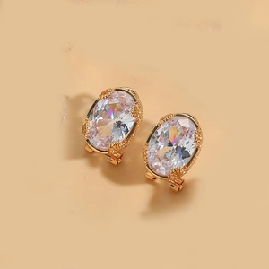 Detail of vintage oval clear crystal drop earrings with polished gold-toned metal setting