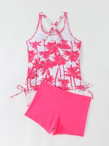 Detail of tropical palm tree print tankini top with crisscross straps and pink boy shorts
