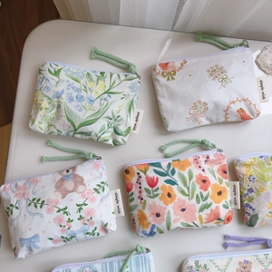 Detailed close-up of floral and bear pattern cotton mini pouches with zipper pulls