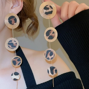 Close-up of golden geometric leopard print leather fringe drop earrings for women