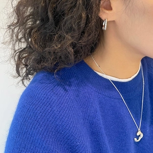 Close-up of twisted 925 sterling silver hoop earrings paired with a dark blue sweater