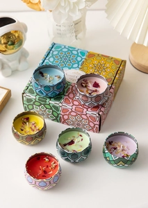 Top view of six colorful soy wax scented candles with dried flowers in a gift box