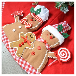 Detail view of plush gingerbread man figurines with chef hats on a festive red tree skirt