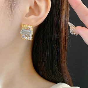 Primo piano della modella con orecchini quadrati placcati in oro con zirconi e perle