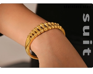 Close-up of gold-plated stainless steel fishbone hollow bracelet with textured metallic links
