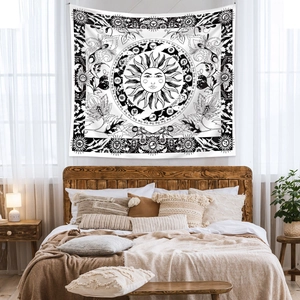 Detailed close-up of Bohemian sun and zodiac tapestry hanging on a cozy bedroom wall