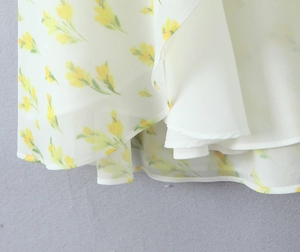 Dettaglio della stampa di limoni gialli su abito in chiffon bianco con fodera interna