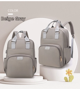Detail view of large-capacity beige mommy backpack with gold zippers and side pockets