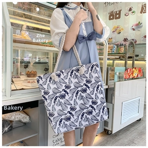 Detail view of large tote bag with tropical leaf print and thick cotton rope handle