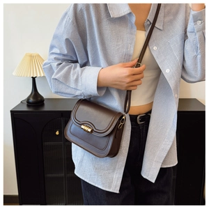 Détail du sac bandoulière vintage marron foncé avec fermoir doré et bandoulière en cuir