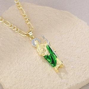 Close-up of Saint Jude pendant with green enamel on a golden Figaro chain necklace