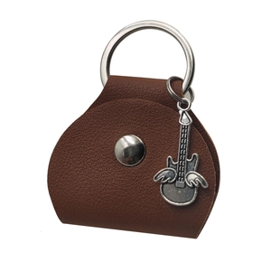Detail view of brown leather guitar pick case with a winged guitar metal keychain pendant