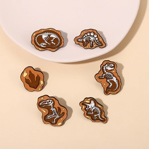 Detailed macro view of 6-piece dinosaur fossil skeleton enamel pins set on a tray