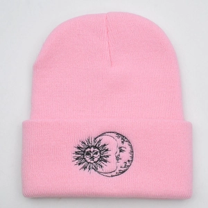 Close-up of pink knitted beanie featuring sun and moon embroidery in fine ribbed texture