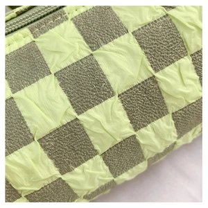 Macro shot of crinkled lime green and dark grey checkerboard fabric with fine stitching