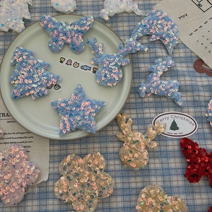 Close-up of sparkling blue and red sequin fabric ornaments in star and deer shapes