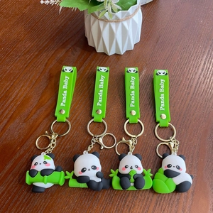 Detail view of four cute panda keychains with green bamboo elements and silicone straps