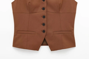 Détails du gilet marron caramel avec quatre boutons noirs et poches décoratives