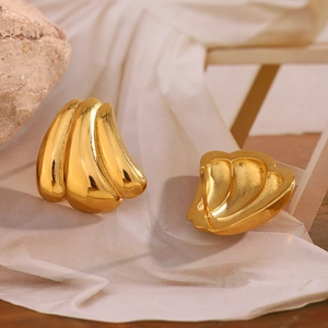 Retro 18K gold plated 316L stainless steel pumpkin stud earrings on silk background