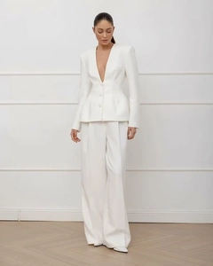 Detail view of women's white deep V-neck blazer with matching wide-leg trousers suit
