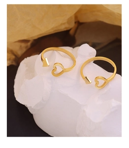 Detailed view of 18K gold plated arrow and heart open ring on a white stone base
