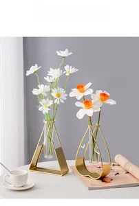 Detail of geometric metal frames in heart and triangle shapes with glass flower tubes