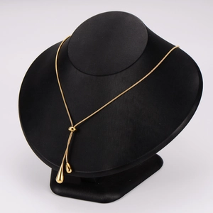 Adjustable Y-shaped gold teardrop tassel necklace displayed on a black bust stand