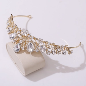 Elegant gold bridal crown with sparkling rhinestones and leaf motifs on display stand