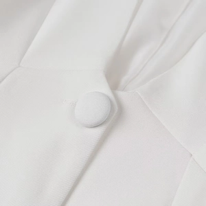 Close-up of white fabric-covered button and twill texture on a women's suit set