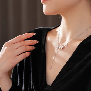 Vue détaillée du collier papillon en argent avec glands en zircon sur le cou du mannequin