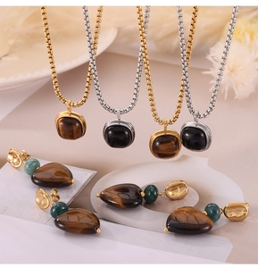 Detail view of vintage tiger eye heart pendants and necklaces on white geometric props
