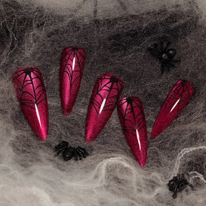 Red cat eye Halloween press-on nails with spider web design in long stiletto shape