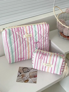 Detail of two-piece quilted makeup bags with colorful stripes and pink bow patterns