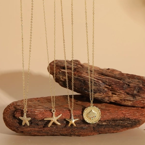 Detail of four gold-toned starfish and scallop shell necklaces with zircon pendants