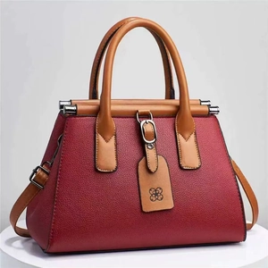 Red litchi grain handbag with brown handles and elegant decorative tag