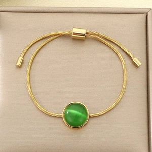 Détail du bracelet chaîne serpent dorée avec pierre œil-de-chat verte et curseur
