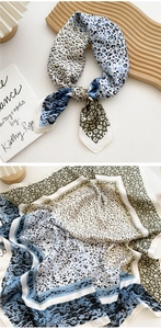 Detail of silk scarf with leopard print patchwork and soft satin texture on wooden tray