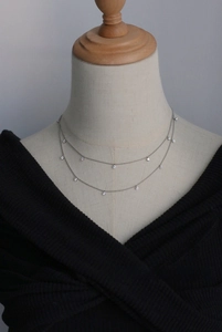 Detail of silver double-layer star necklace with sparkling cubic zirconia on mannequin