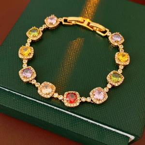 Detail of vintage gold bracelet with colorful square zircon stones on green jewelry box