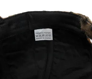 Close-up of the wash care label showing 100% polyester material on the leopard baseball cap