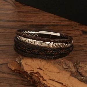 Close-up of multi-layer brown braided leather bracelet with silver metal chain elements